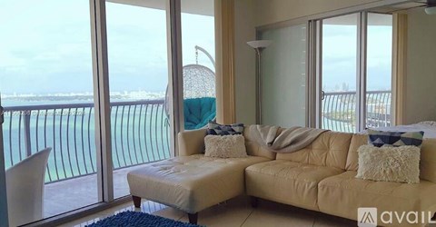 A living room with a couch and a view of the ocean.