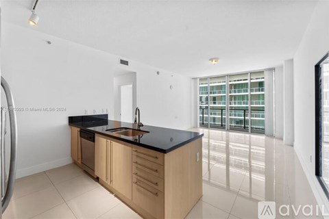 A modern kitchen with wooden cabinets and a black countertop.