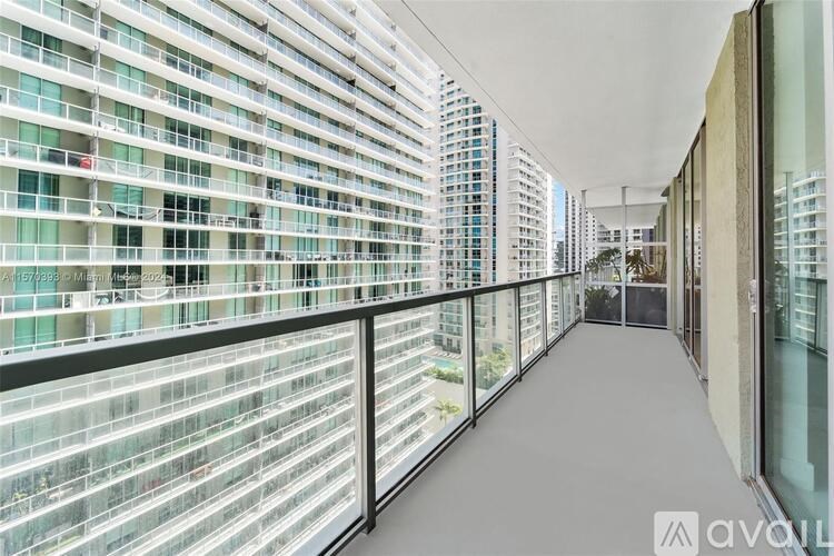 A long balcony with glass railings overlooks a cityscape.