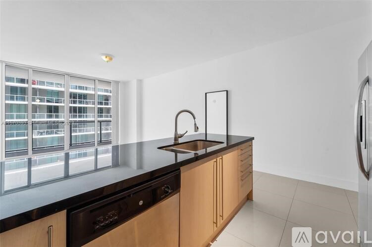 A kitchen with wooden cabinets and a black countertop.
