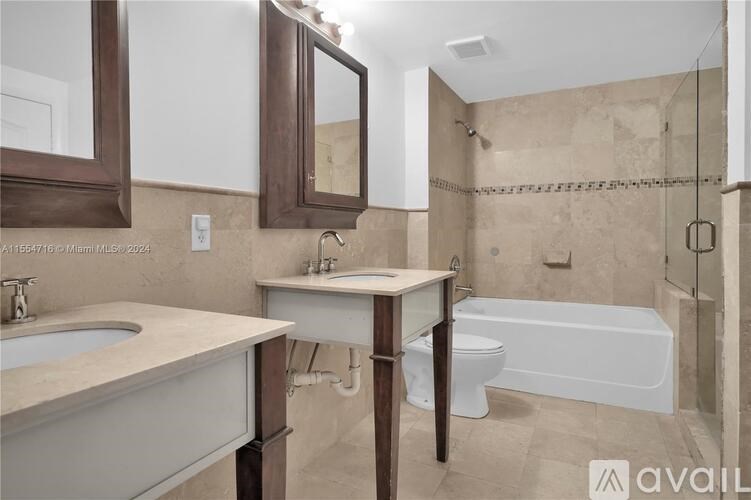 A bathroom with a tub, sink, and mirror.
