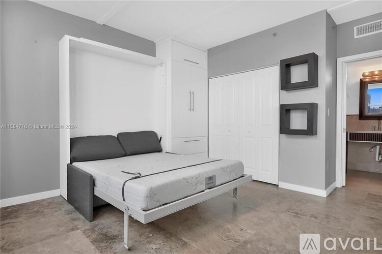 A bedroom with a bed, a dresser, and a TV.