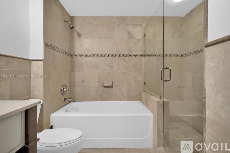A bathroom with a white bathtub and toilet.
