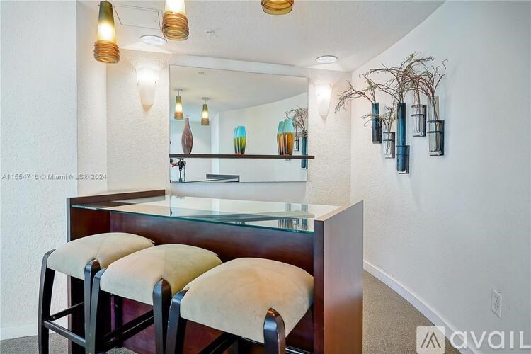 A bar area with a glass counter and three stools.