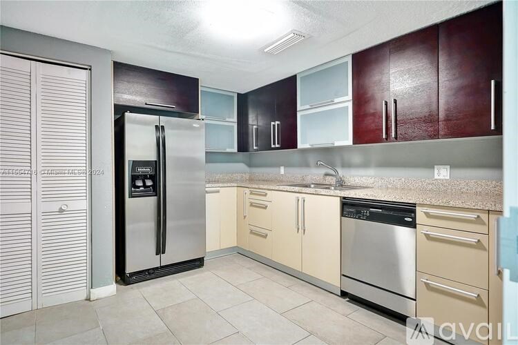 A kitchen with a stainless steel refrigerator and wooden cabinets.