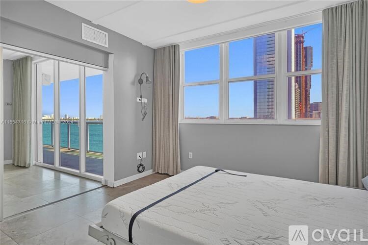 A bedroom with a large bed and a view of the city.
