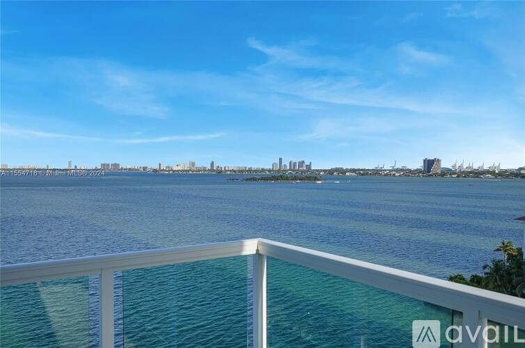 A view from a balcony overlooking a body of water with buildings in the distance.