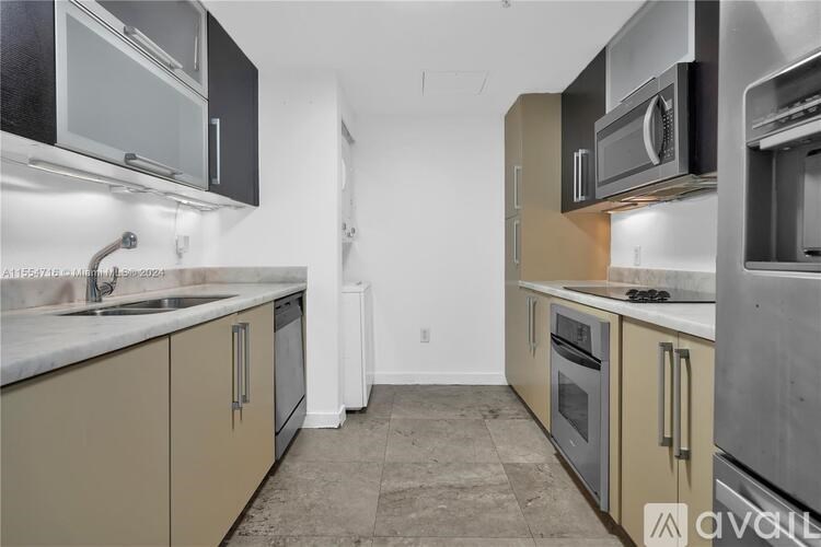 A kitchen with beige cabinets and stainless steel appliances is available for rent.