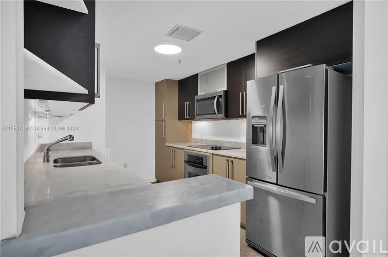 A modern kitchen with stainless steel appliances and a large island.