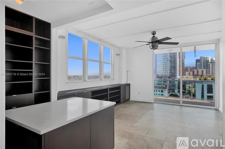A modern kitchen with a large island and a view of the city.