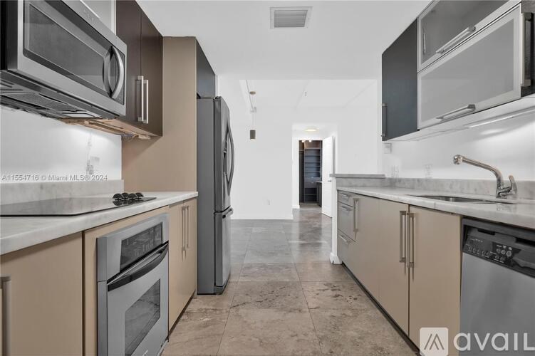 A kitchen with beige cabinets and stainless steel appliances is available for rent.