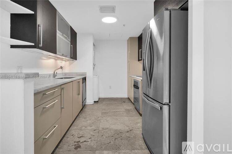 A kitchen with a refrigerator, oven, and microwave.
