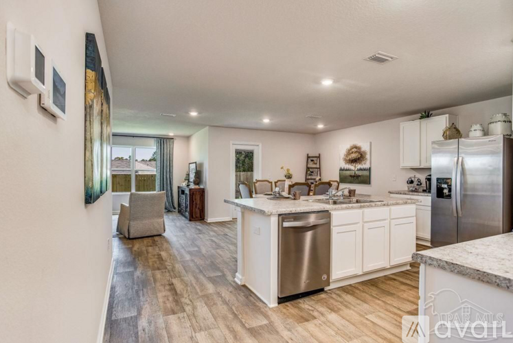 A kitchen with white cabinets and a marble countertop.