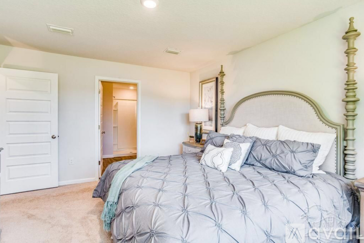 A bedroom with a large bed and a white door.