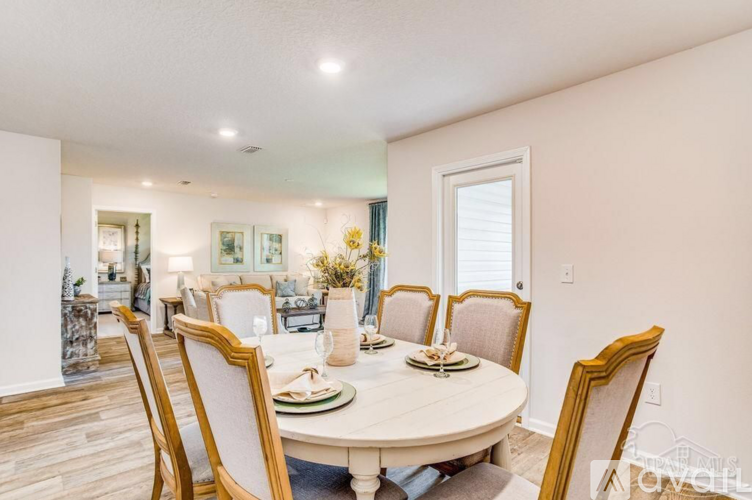 A dining room with a round table and chairs.