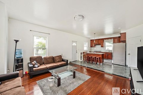 A living room with a brown sofa and a glass coffee table.