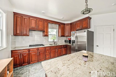 A kitchen with wooden cabinets and granite countertops is available for rent.