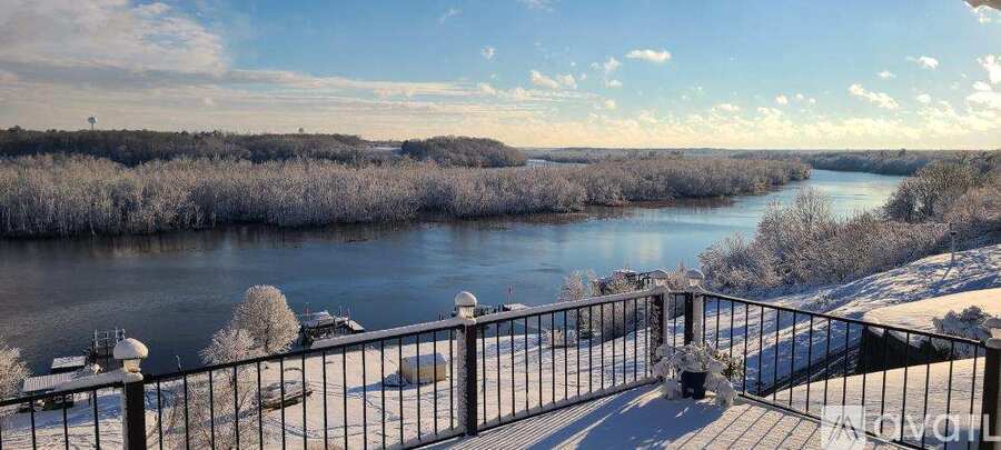 A river flows through a snowy landscape with trees on both sides.