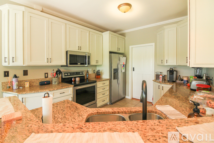 A kitchen with a granite counter top and stainless steel appliances.