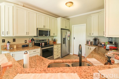A kitchen with a granite counter top and stainless steel appliances.