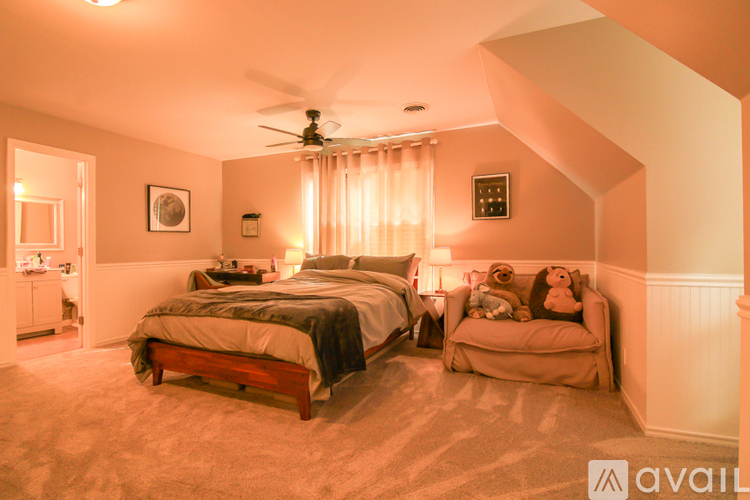 A bedroom with a bed and a chair.