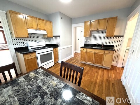A kitchen with wooden cabinets and a marble table.