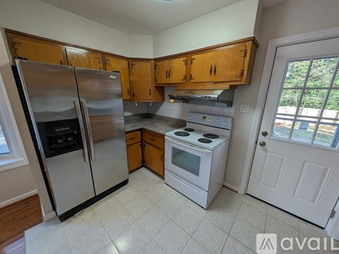 A kitchen with wooden cabinets and a white stove top oven.