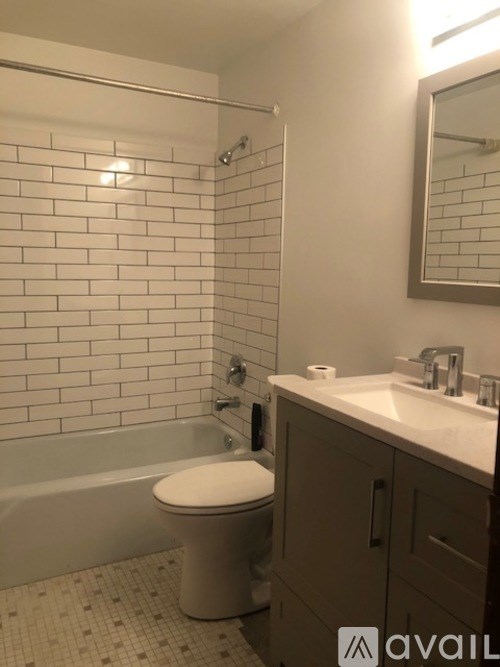 A white toilet sits in a bathroom next to a sink.