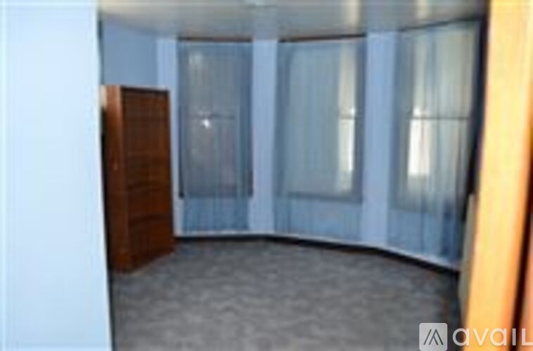 A room with a carpeted floor and a wooden door.