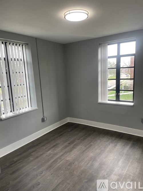 A room with a window and a wall-mounted light fixture.