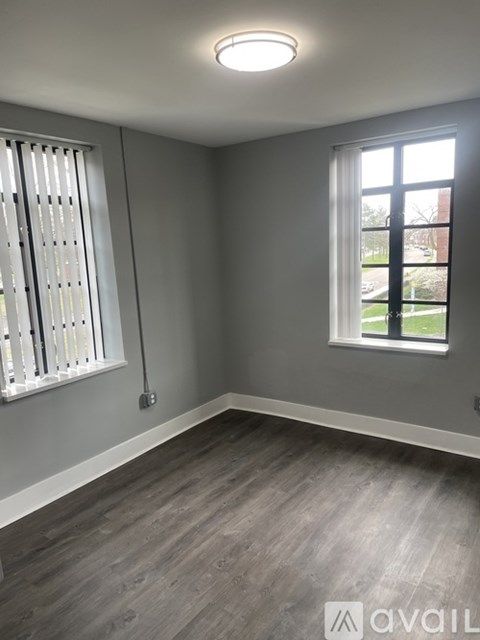 A room with a window and a wall-mounted light fixture.