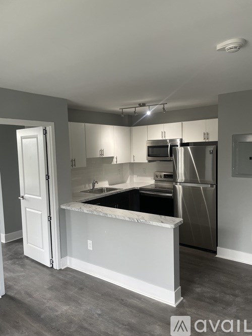 A kitchen with a white counter and stainless steel appliances.