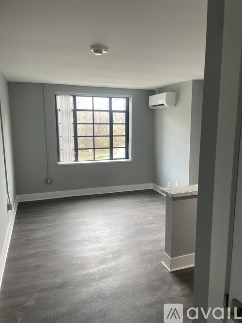 A room with a window and a wall-mounted air conditioner unit.