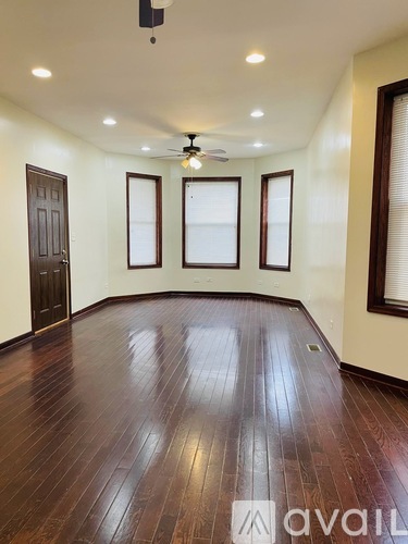 A room with wooden floors and a ceiling fan.