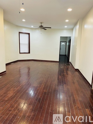 A room with wooden flooring and a ceiling fan.
