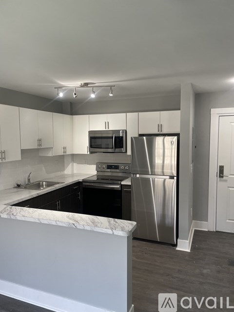 A kitchen with a marble countertop and stainless steel appliances.