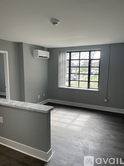 A room with a window and a marble counter.