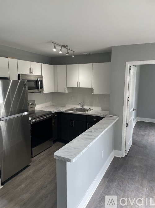 A kitchen with a refrigerator, microwave, and oven.
