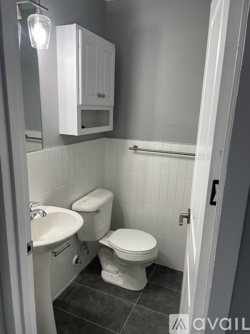 A bathroom with a toilet, sink, and medicine cabinet.