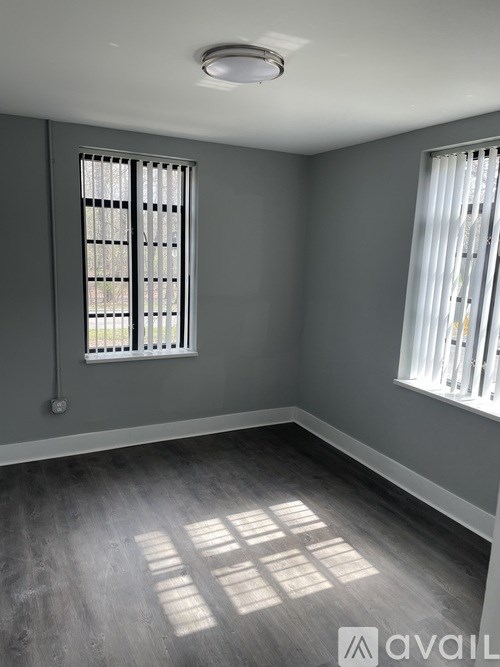 A room with grey walls and a window with blinds.