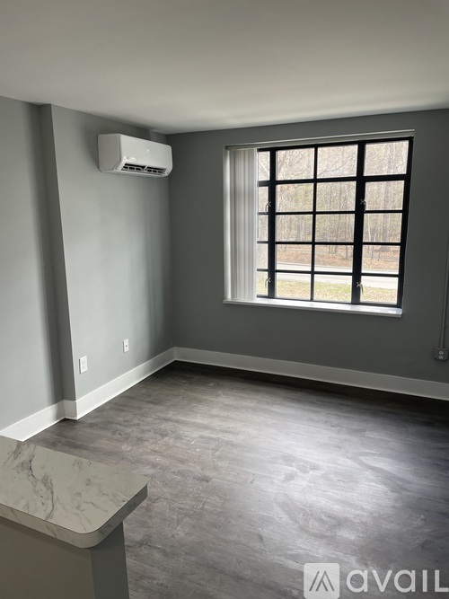A room with a window and a wall-mounted air conditioner unit.