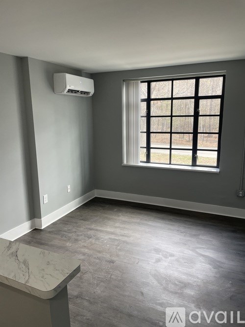 A room with a window and a wall-mounted air conditioner unit.