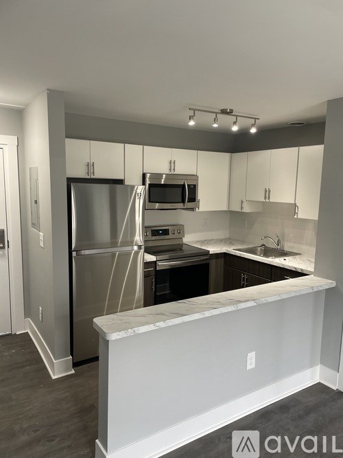 A kitchen with a white counter and stainless steel appliances.