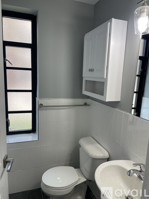 A white toilet and sink in a small bathroom.