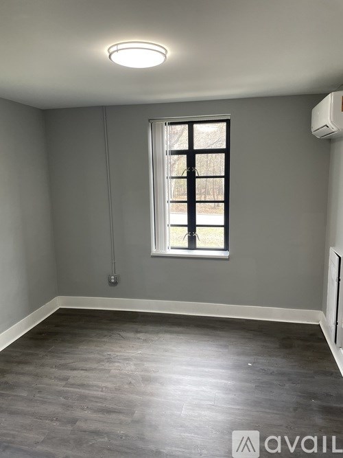 A room with a window and a wall-mounted air conditioner unit.