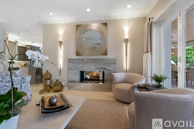 A modern living room with a fireplace and a large mirror on the wall.