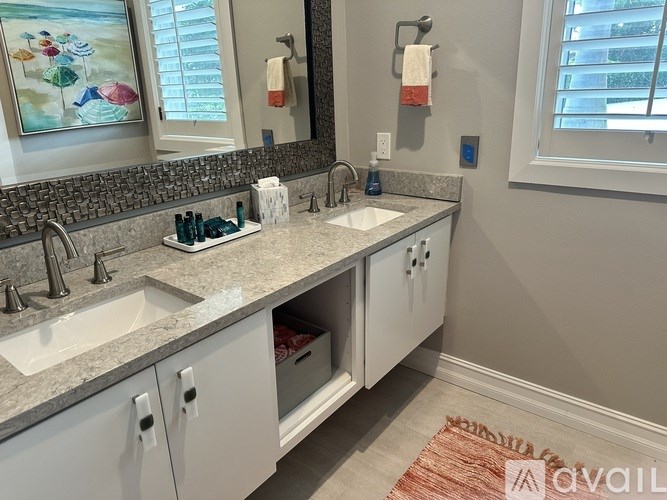 A bathroom with two sinks and a large mirror.