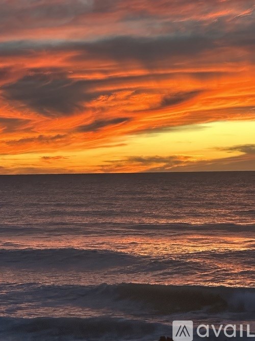A beautiful sunset over the ocean with waves crashing onto the shore.