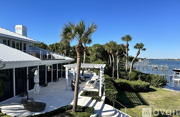 A white building with a balcony overlooking a body of water.