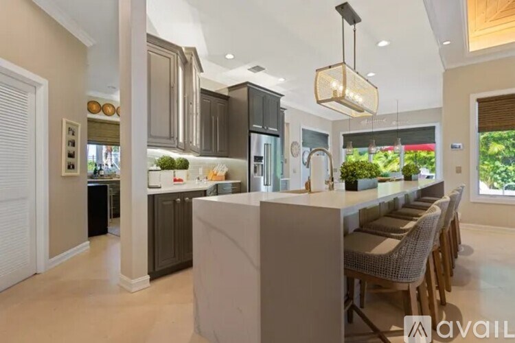 A modern kitchen with a large island and a dining area.